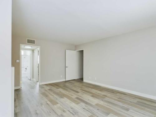 Apartments  for rent in Encino Empty room with light-colored hardwood flooring, off-white walls, and an open door leading to a bathroom with tiles. Room has a modern, minimalist design. White Oak Apartments in Encino 5465 White Oak Avenue Encino, CA 91316  P: 866-471-5691 TTY: 711 F: 818-647-0393