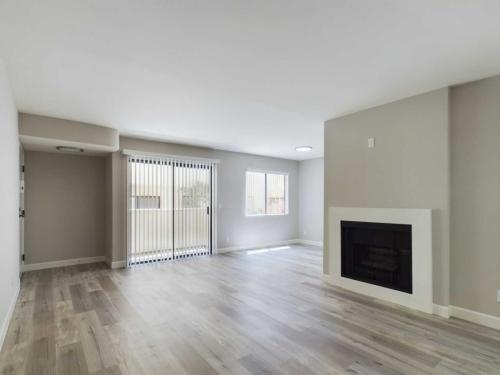 Apartments  for rent in Encino A spacious empty room with light-colored wooden flooring, large sliding glass doors, windows, and a built-in fireplace. White Oak Apartments in Encino 5465 White Oak Avenue Encino, CA 91316  P: 866-471-5691 TTY: 711 F: 818-647-0393